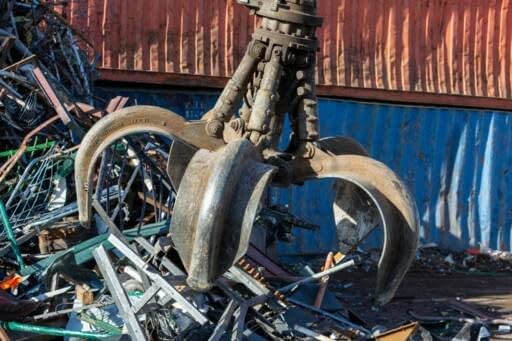 Garra hidráulica recogiendo chatarra metálica en planta de reciclaje Toferla Madrid